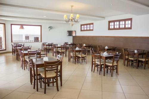 uma sala de jantar com mesas e cadeiras de madeira em Hotel Pousada Trevo em Jequié