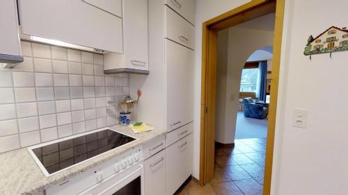 シルヴァプラーナにあるTscheppa 3の白いキャビネットとシンク付きのキッチン