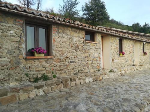 a stone house with a window and flowers on it at Il Cerro Agriturismo Zagarese in Fuscaldo