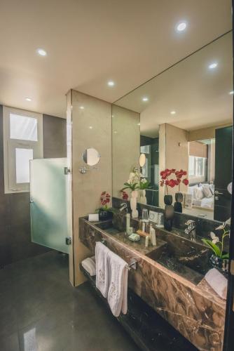 a bathroom with a sink and a large mirror at Louis V Hotel Beirut in Beirut