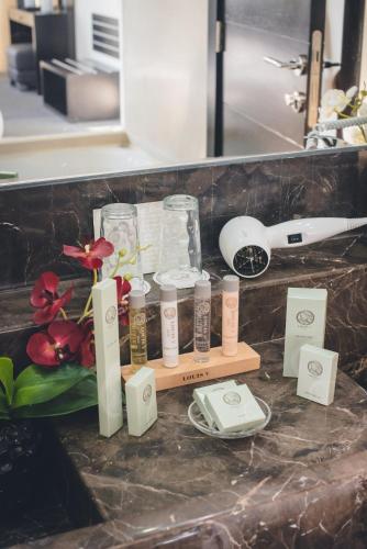 a bathroom counter with a bunch of products on it at Louis V Hotel Beirut in Beirut