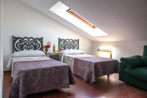 een kamer met 2 bedden en een bank bij Casa Pichon Etxea in La puebla de Labarca 