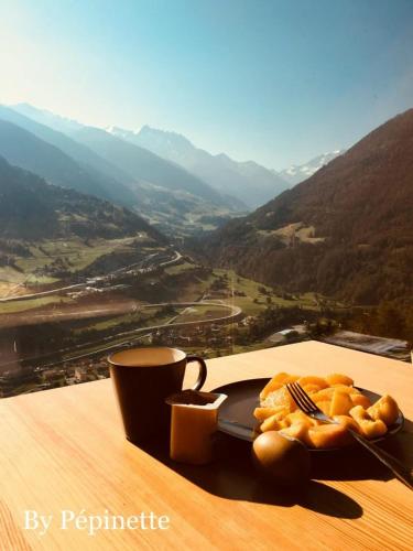 a table with a plate of food and a cup of coffee at Chalet Le Biolley in Orsières