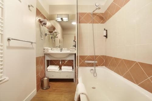La salle de bains est pourvue d'une baignoire et d'un lavabo. dans l'établissement Odalys City Aix en Provence Les Floridianes, à Aix-en-Provence