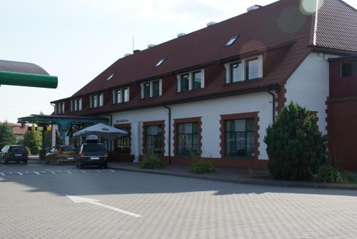 a building with a car parked in front of it at Motel Warmiaki Bed&breakfast in Jadów