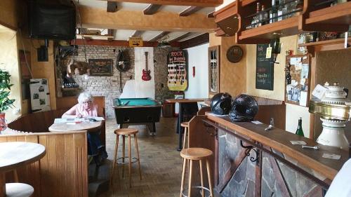 a woman sitting at a bar in a pub at Vogtshof von Wetteldorf in Schönecken