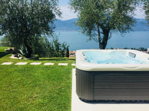 a bath tub sitting in the grass next to the water at Ca' Campitol in Torri del Benaco