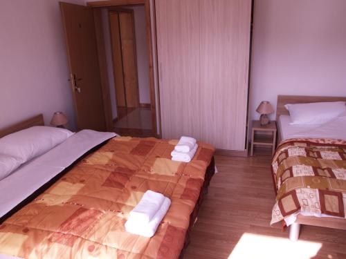 Dos camas en una habitación de hotel con toallas. en Villa Ana, en Međugorje