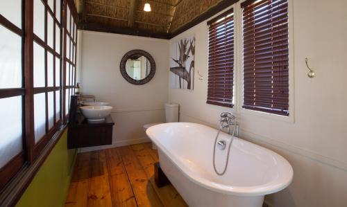 een badkamer met een wit bad en een wastafel bij Felix Unite Provenance Camp in Noordoewer