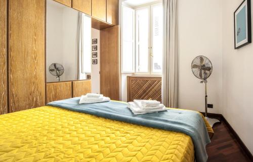 a bedroom with a yellow bed in a room with a window at Rome As You Feel - Baccina 95 Forum Apartment in Rome