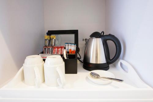 a coffee pot and cups on a white counter at Mantis St Helena in Jamestown