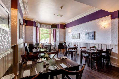 a dining room with wooden tables and chairs at Inn At The Park Hotel in Aberdeen