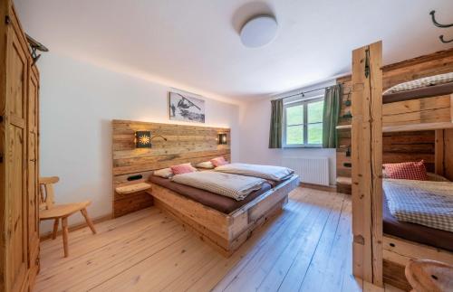 a bedroom with two bunk beds and wooden walls at Getznerhof in Westendorf
