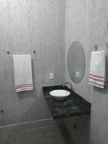 a bathroom with a sink and a mirror and towels at Orla Piaui in Luis Correia