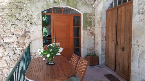 Gite Le Moulin de Rosieres Moulin Champetier في Rosières: طاولة خشبية عليها إناء من الزهور