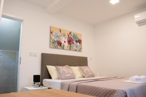 a bedroom with a bed and a painting on the wall at Airport room's Residence Garden in Velika Gorica