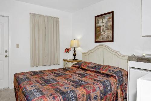 a bedroom with a bed with a colorful blanket at Shell Motel Hollywood in Hollywood