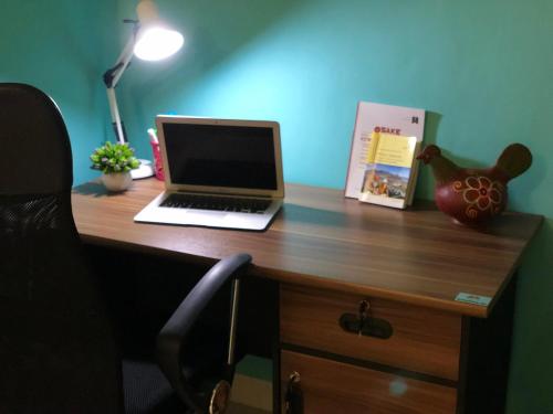 a laptop computer sitting on top of a wooden desk at Fullhouse in Mataram