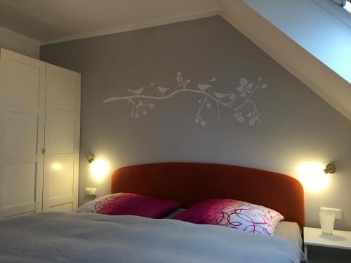 a bedroom with a bed with a branch on the wall at Hafenidyll mit Wasserblick in Ostseebad Karlshagen