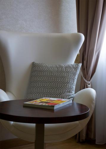 a book on a table on a chair with a pillow at Hotel Meira in Vila Praia de Âncora