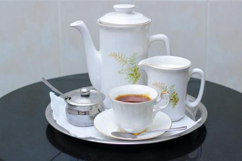 uma bandeja com um bule de chá e uma chávena de chá em Unique Bed and Breakfast em Harare