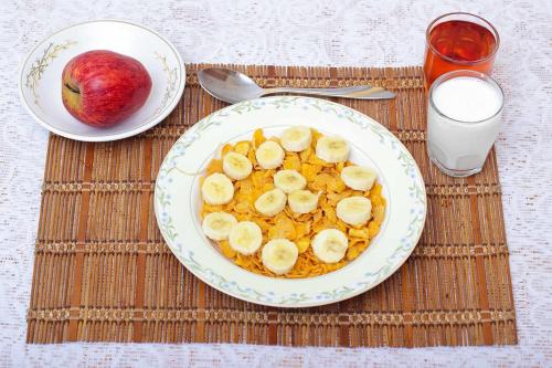 a plate of food with bananas and apples on a table at Unique Bed and Breakfast in Harare