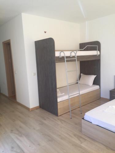 a bedroom with a bunk bed with a ladder at Guest House ASK in Primorsko
