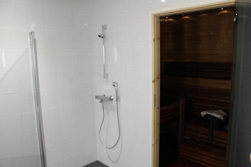 y baño con ducha y puerta de cristal. en Apartment Puistotie 4, en Pyhäjoki