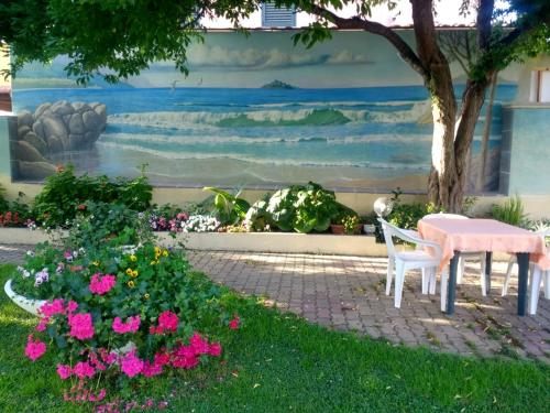 a table and chairs in front of a wall with a painting at Casa Vacanze Arba Girasole in Girasole