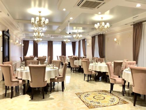 a dining room with tables and chairs and chandeliers at Hotel Boutique TOVMED in Vinnytsya
