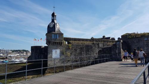 a building with a clock tower on top of it at 2 Maisons de vacances Sittelles Lodge in Concarneau