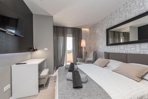 um quarto com uma grande cama branca e uma secretária em Luxury Apartments Garden em Sukošan