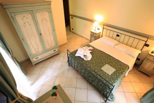 a small bedroom with a bed and a dresser at Hotel L'Aquila in LʼAquila