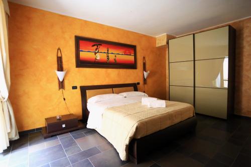 a bedroom with a bed and a painting on the wall at Hotel L'Aquila in LʼAquila
