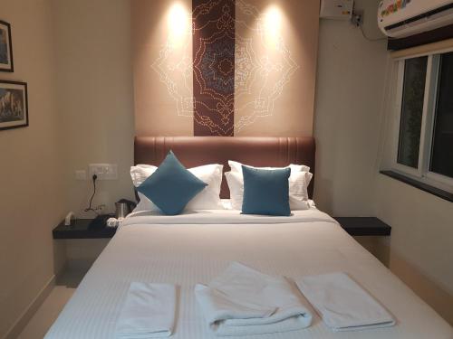 a bedroom with a bed with two towels on it at The Bull Boutique Hotel in Puducherry