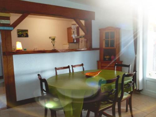 a dining room with a green table and chairs at Gîte Bien Etre in Boulogne-sur-Gesse