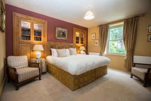 a bedroom with a large bed and two chairs at The Cornmill in Kirkbymoorside