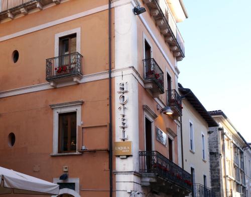 a building with a sign on the side of it at Hotel L'Aquila in LʼAquila