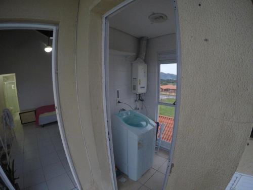 a mirror reflection of a bathroom with a window at Apartamento no Residencial Amazônia I in Florianópolis