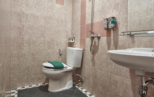 a bathroom with a toilet and a sink at Twins Hotel in Jakarta