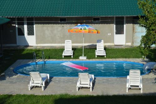 einen Pool mit Stühlen und einem Sonnenschirm in der Unterkunft Hotel Tedi in Qwareli