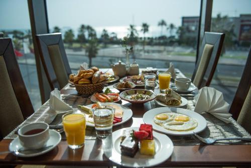a table with breakfast food and orange juice on it at Kuwait Grand Hotel in Kuwait