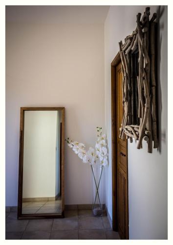 a hallway with a mirror and a vase of flowers at Villa 4 étoiles Sole di Corsica in Cauro