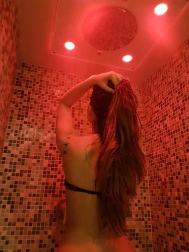a woman in a bathroom with her long hair at Residence Adamello Resort in Ponte di Legno