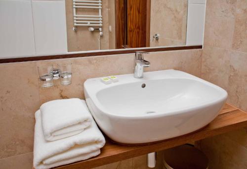 a bathroom with a sink and a mirror and towels at Best Western Hotel Jurata in Jurata