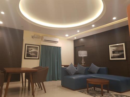 a living room with a blue couch and a table at The Bull Boutique Hotel in Puducherry