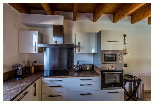 a kitchen with white cabinets and a stove top oven at Villa 4 étoiles Sole di Corsica in Cauro