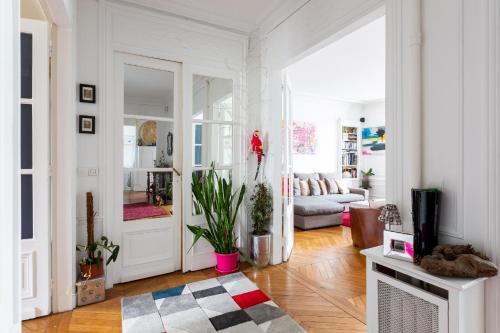 - un salon blanc avec un canapé et une porte dans l'établissement Veeve - Balcony Bliss, à Paris
