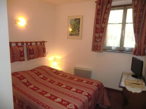 een slaapkamer met een bed met een rode deken bij Gite "Karcher" in Colmar