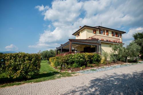 a house with a balcony on the side of a road at Agriturismo Il Giardino Degli Ulivi in Lazise